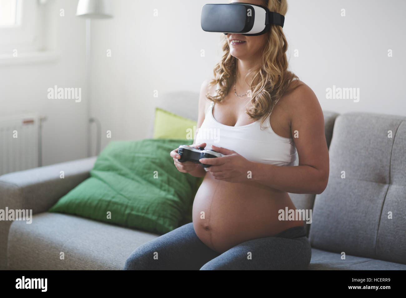 Beautiful pregnant woman enjoying VR Stock Photo