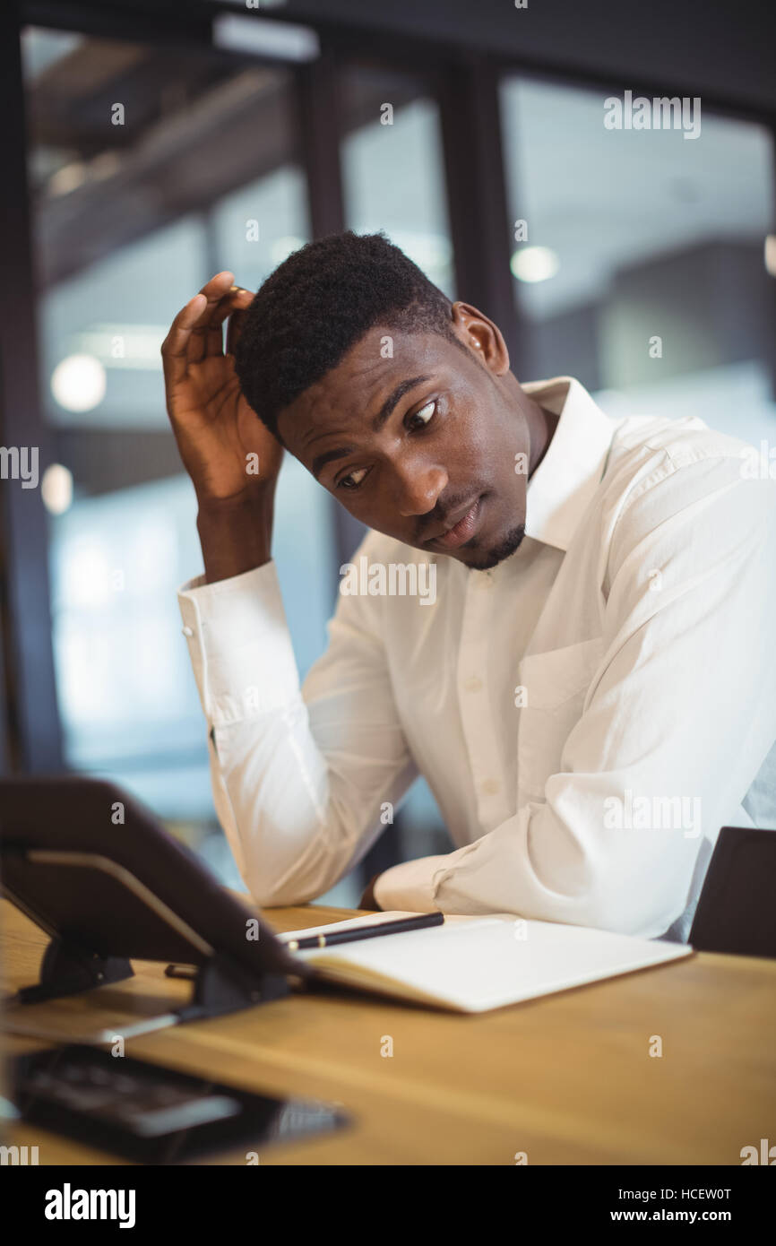 Thoughtful businessman working over digital tablet Stock Photo
