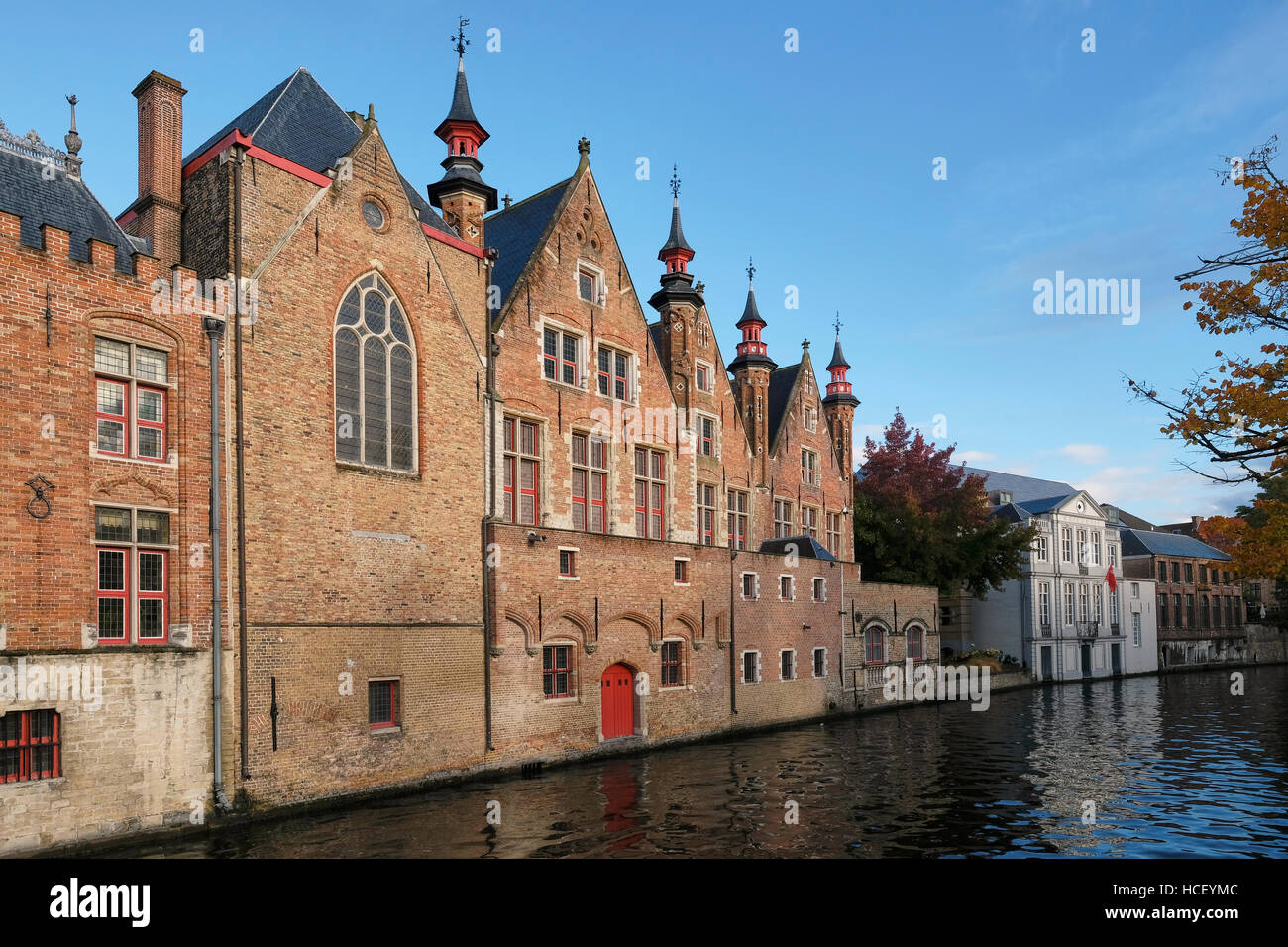 Red brick canal side buildings on the Groenerie canal, . Building on the left is part of the Oude Civiele Griffie (Old County Registry), the  Gothic b Stock Photo