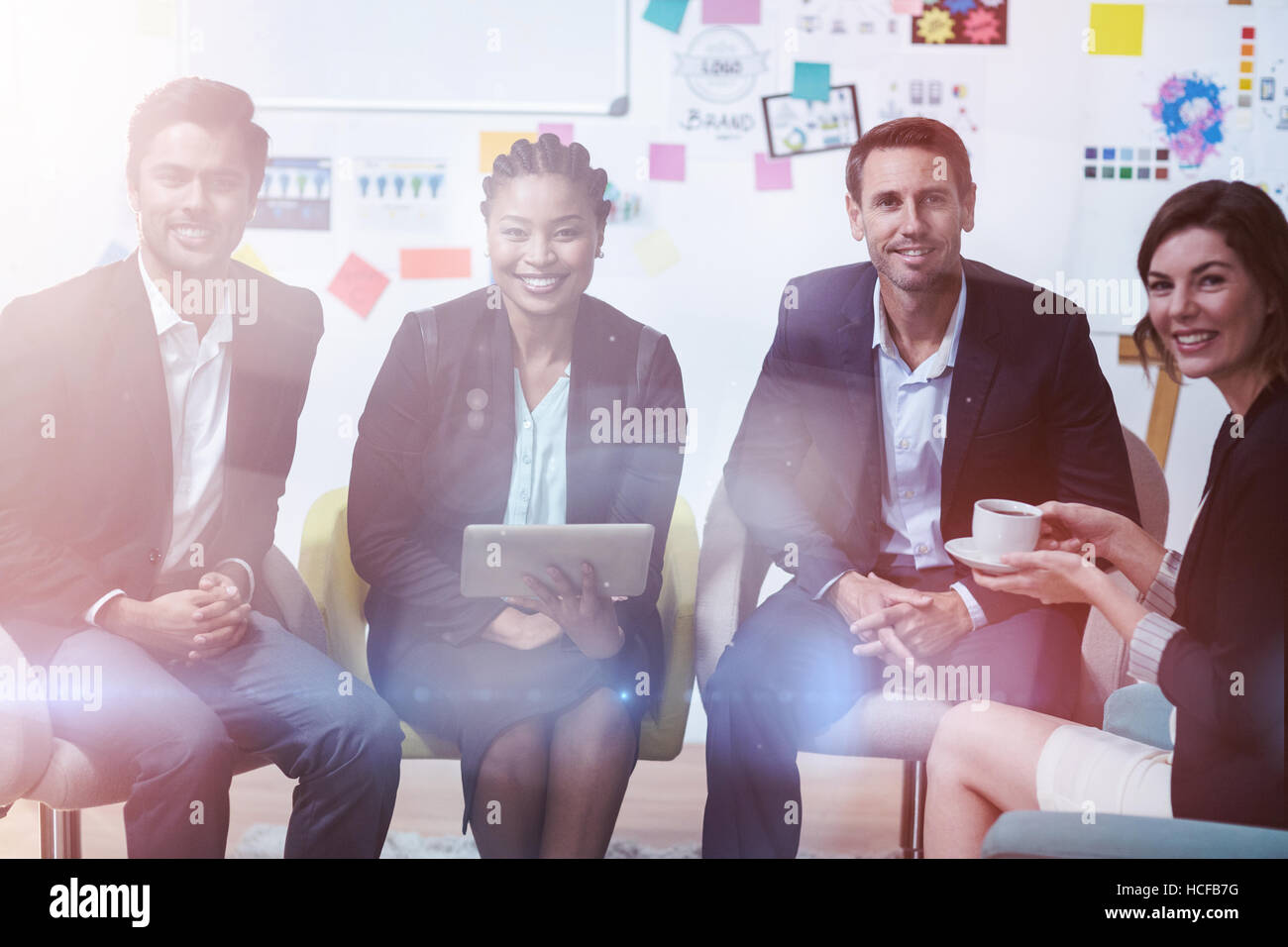 Smiling businesspeople sitting in office Stock Photo - Alamy