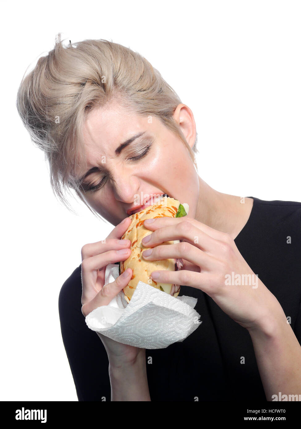 A image of a attractive woman eating a deli style sandwich. Stock Photo
