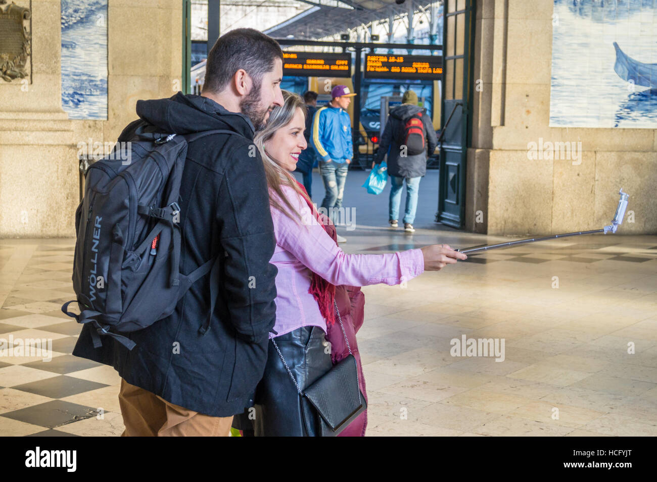 A couple taking a selfie portrait, Saõ Bento railway station, Porto Portugal Stock Photo