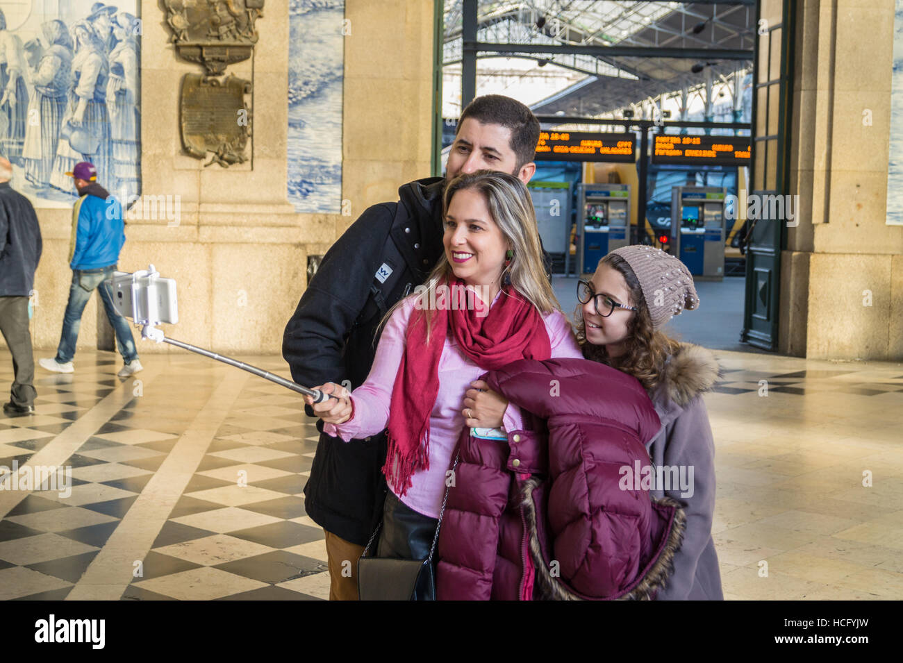A young family taking a selfie portrait, Saõ Bento railway station, Porto Portugal Stock Photo