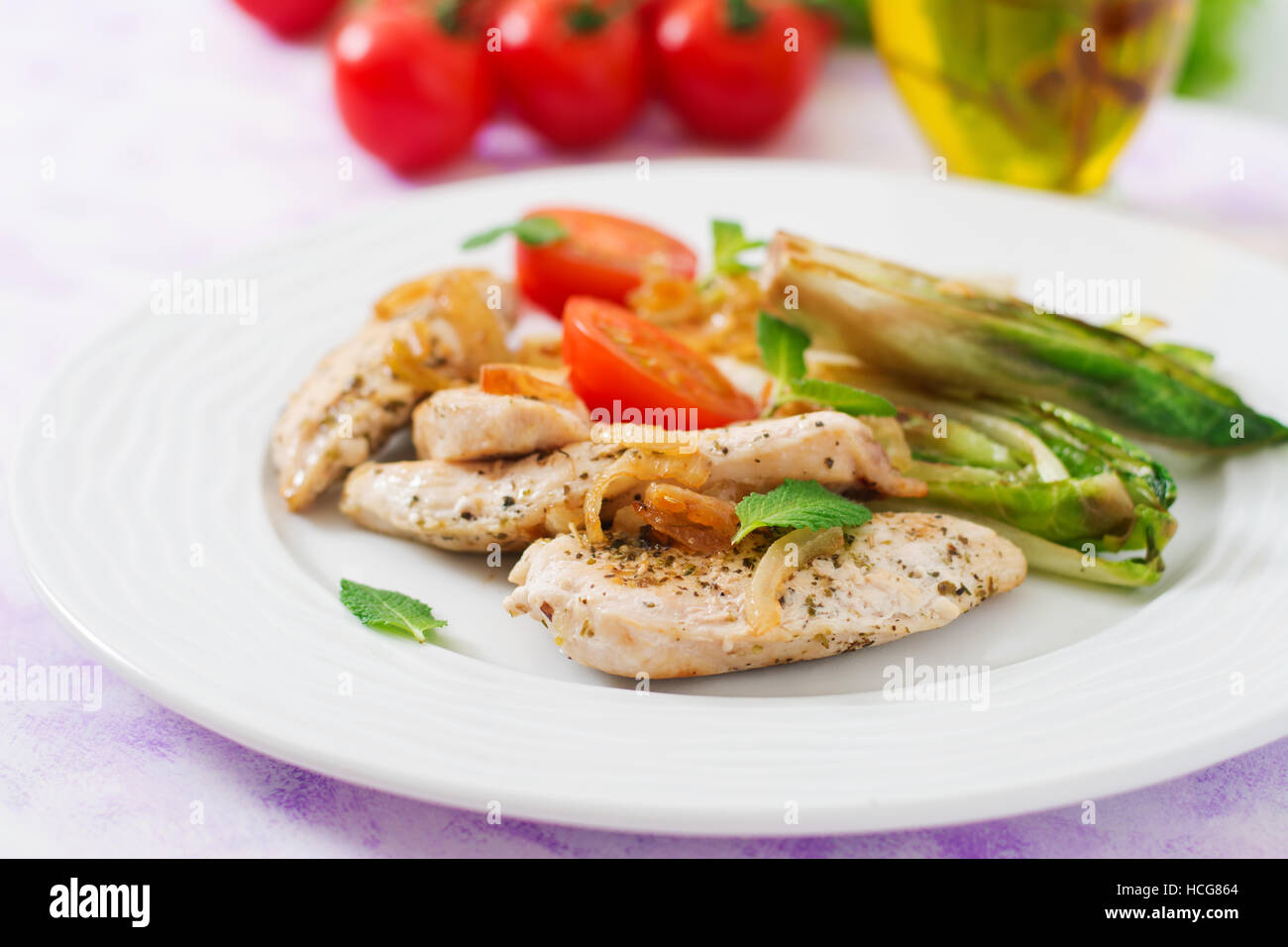 Baked chicory with chicken, onions and herbs. Stock Photo