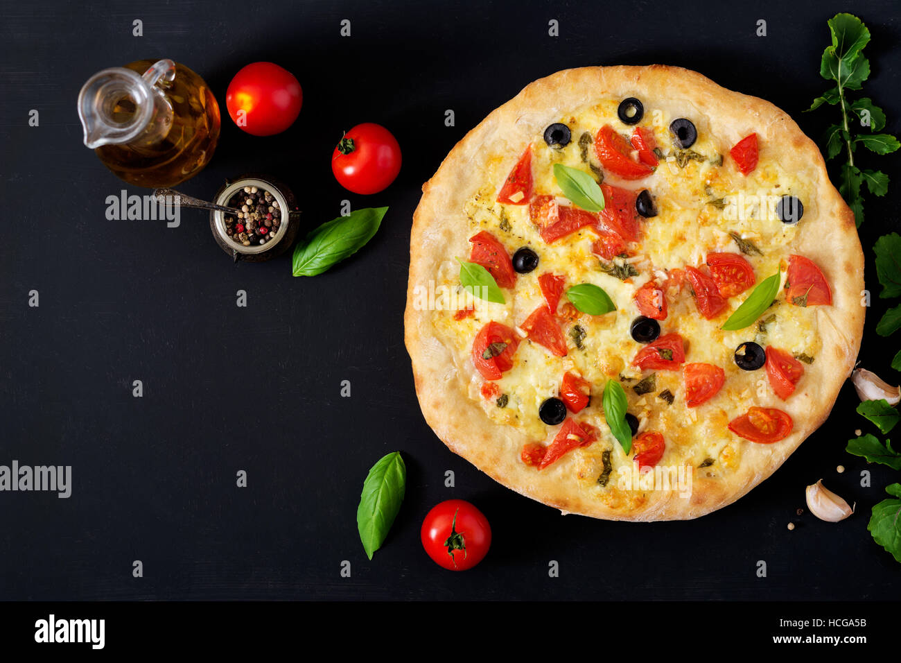 Pizza with tomato, mozzarella, basil and olives. Top view Stock Photo