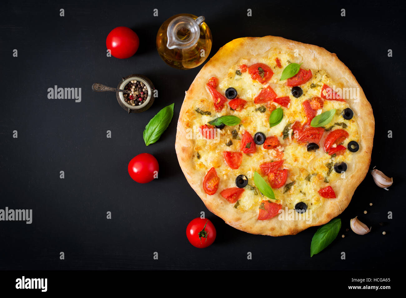 Pizza with tomato, mozzarella, basil and olives. Top view Stock Photo