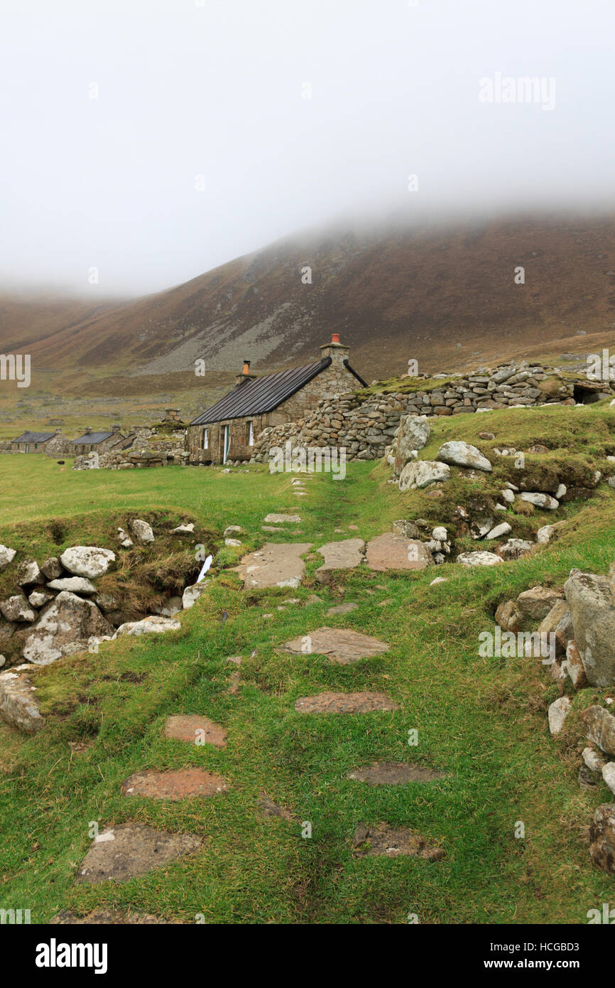 'The Street', a stone path lined with restored historic cottages, part of an ancient abandoned settlement on St Kilda, Scotland. Stock Photo