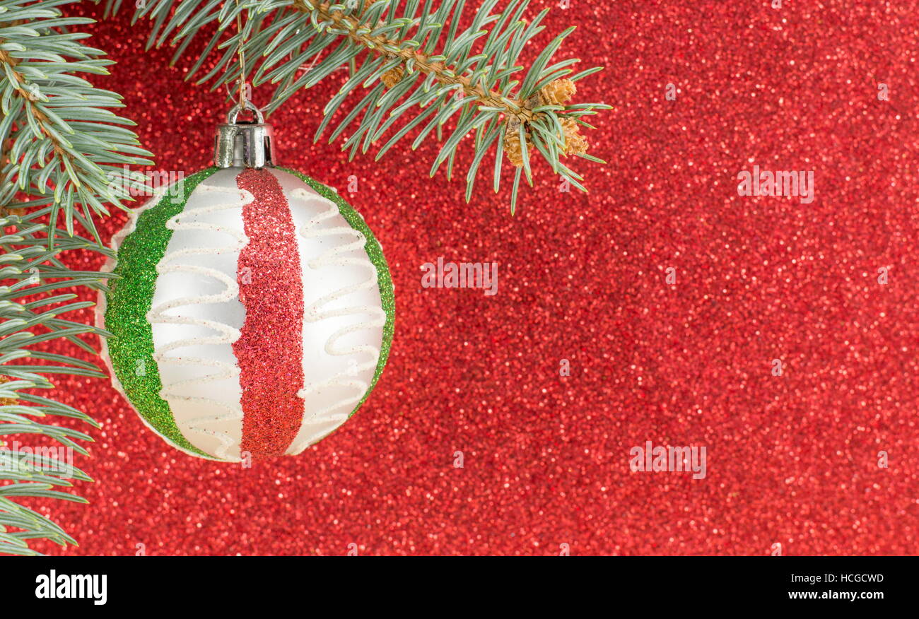 Christmas decorations and fir tree against red shiny background Stock Photo