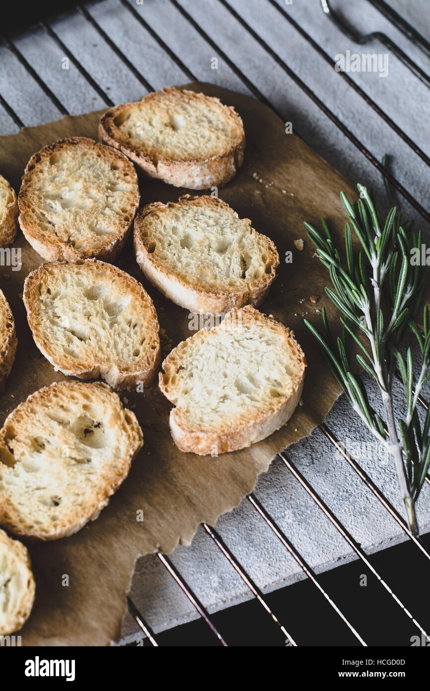 https://c8.alamy.com/comp/HCGD0D/toasted-baguette-bread-on-parchment-paper-on-cooling-rack-HCGD0D.jpg