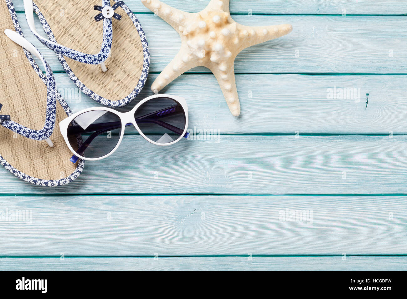 Beach accessories. Flip flops, sunglasses and starfish on wooden ...