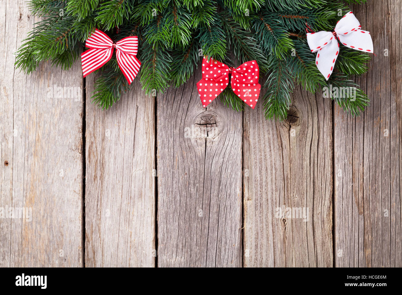 Christmas wooden background with fir tree and ribbon bow. View with ...