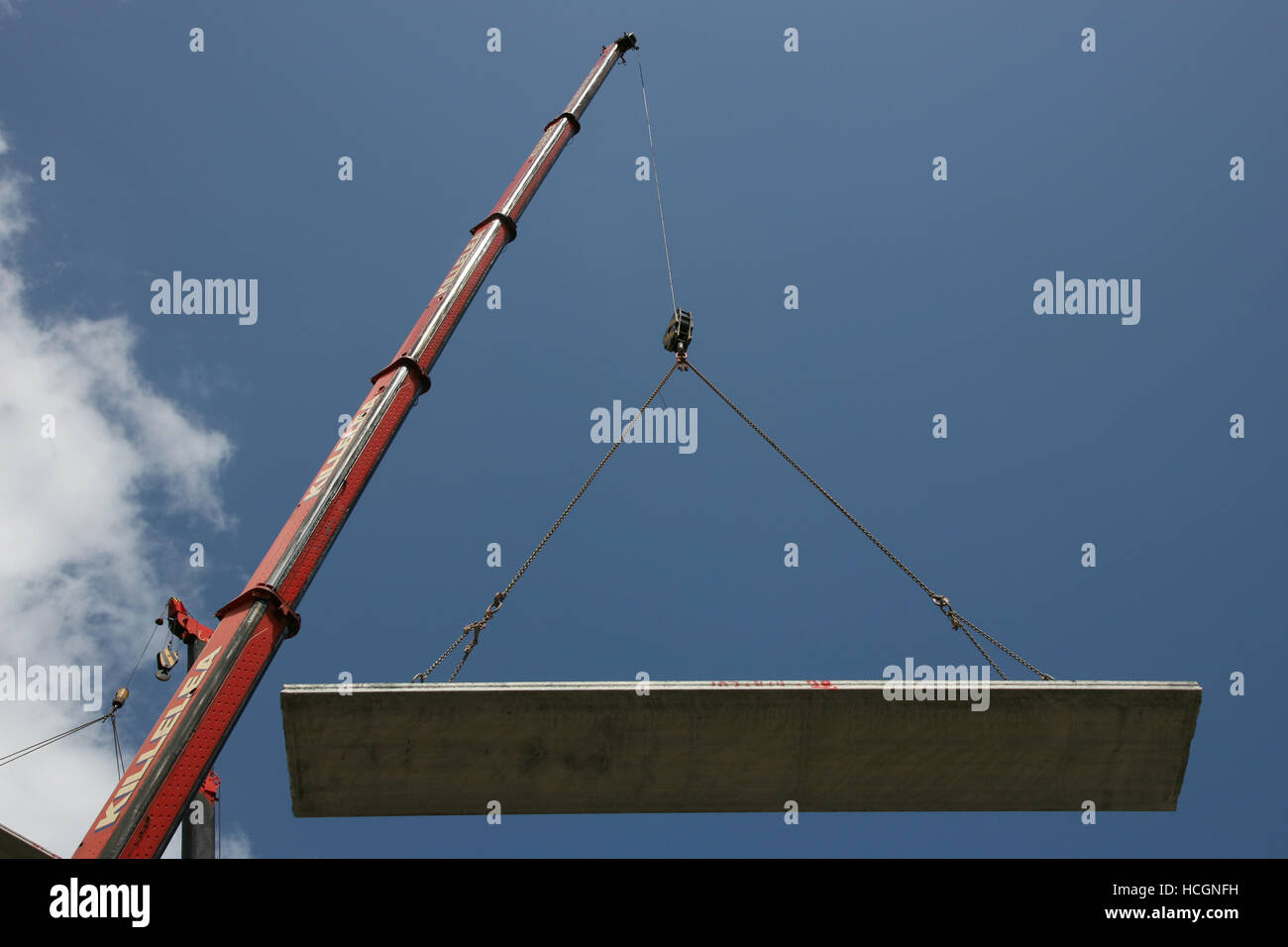 Precast concrete hollow floor slab / plank suspended from a mobile crane. Stock Photo