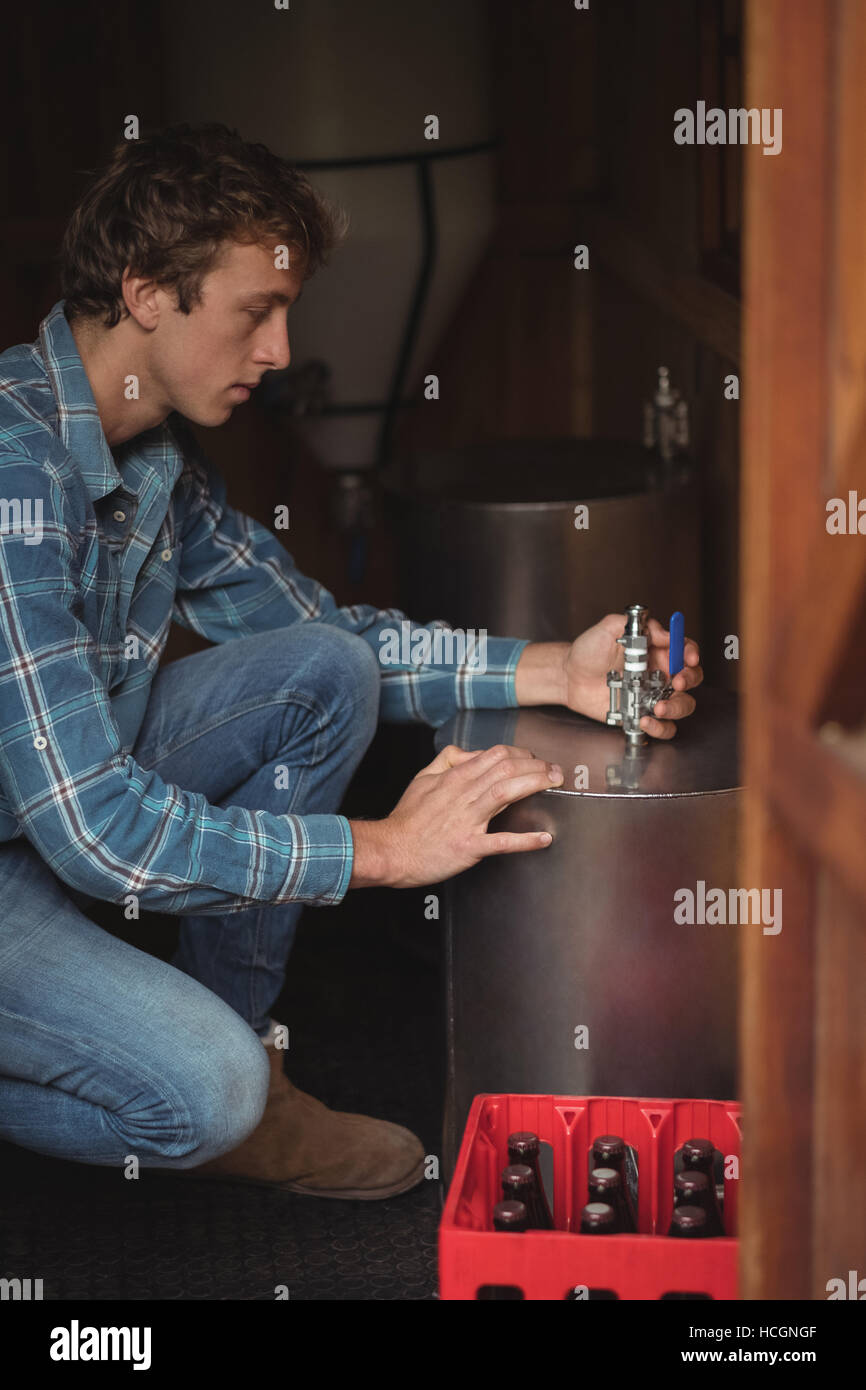 Man fixing valve to beer wort to make beer Stock Photo Alamy
