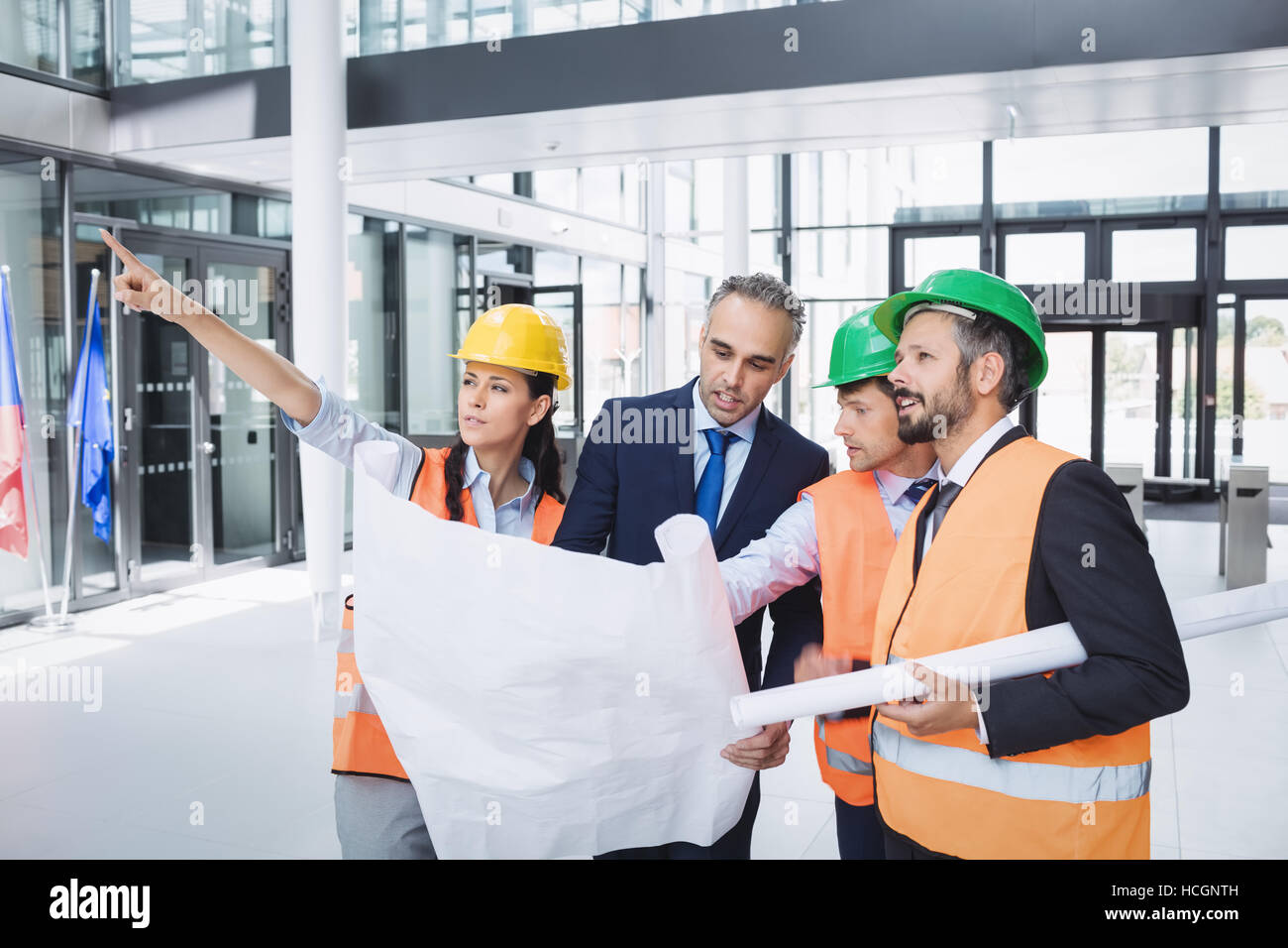 Businessman discussing on blueprint with architects Stock Photo