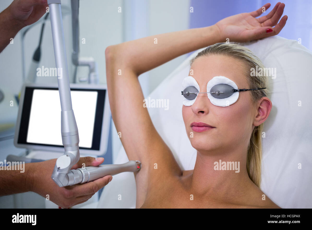 Dermatologist removing hair of patient armpit Stock Photo
