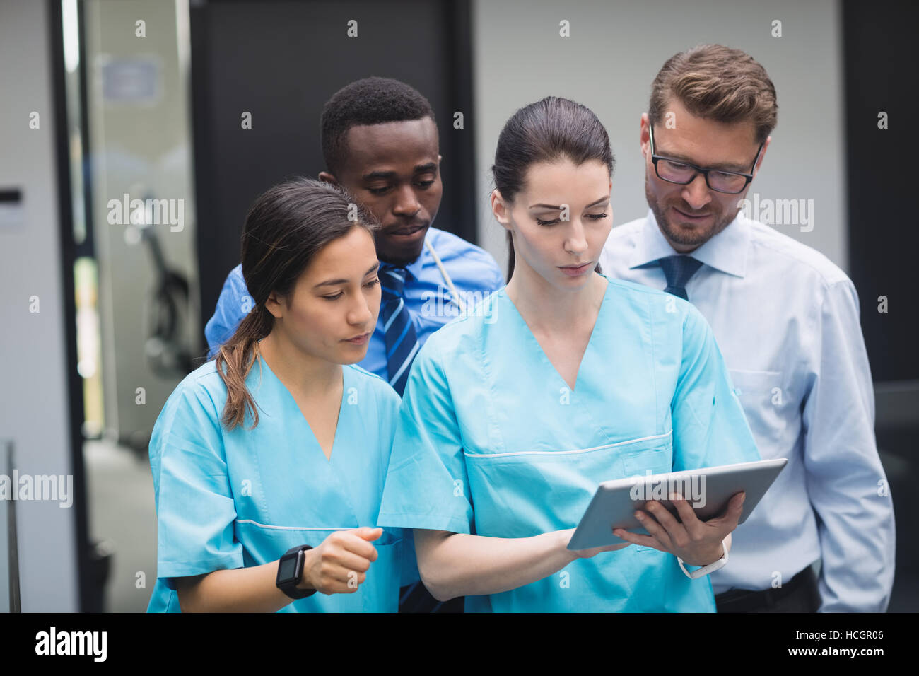 Medical team discussing over digital tablet Stock Photo