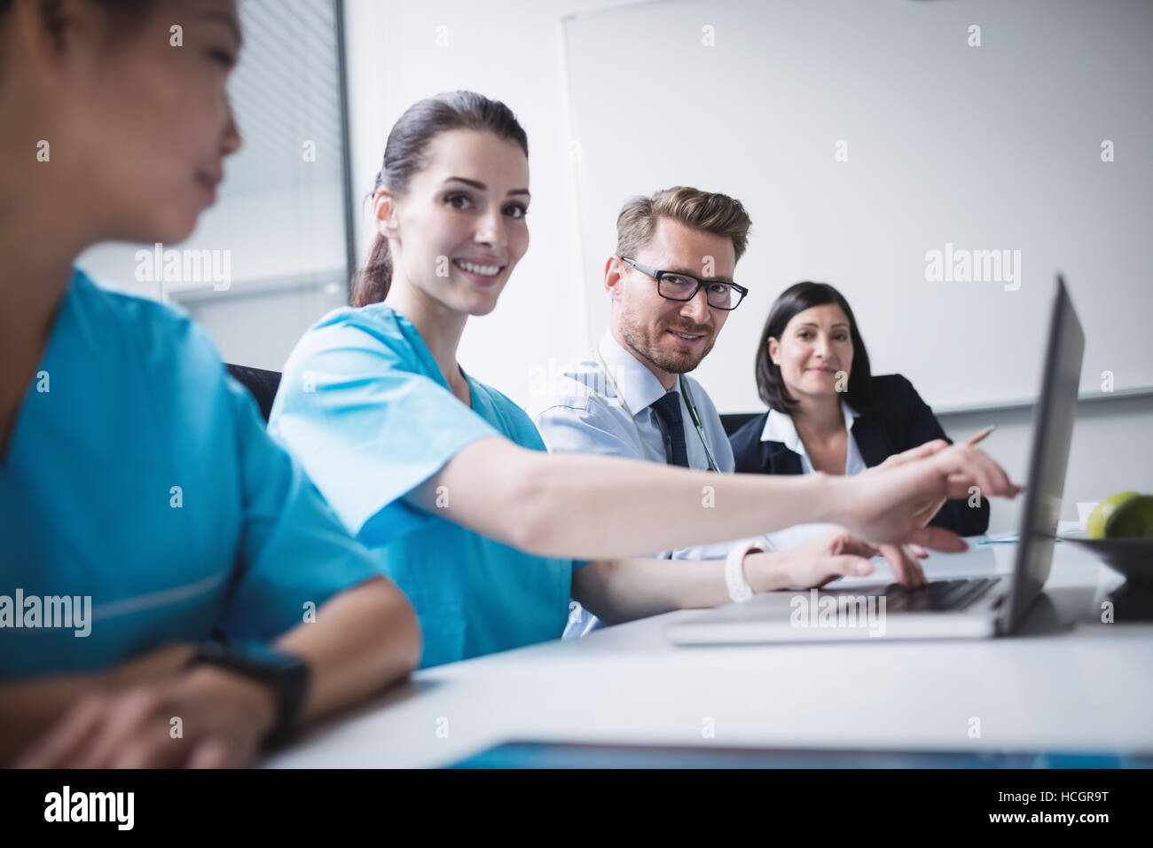 Doctors discussing over laptop in meeting Stock Photo