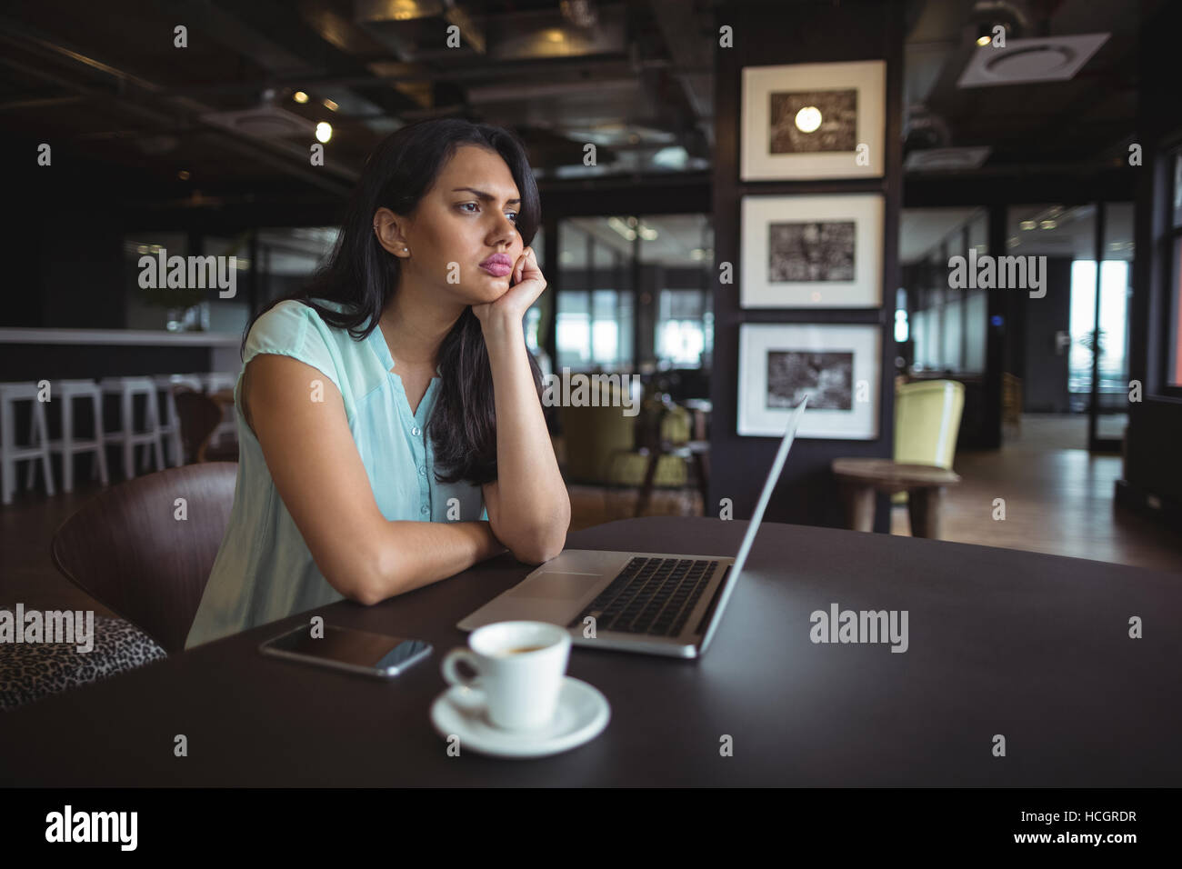 Upset businesswoman sitting at her desk Stock Photo
