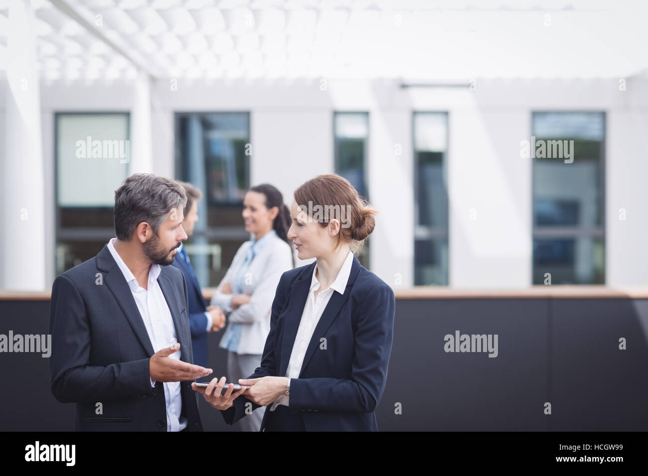 Businesspeople discussing over digital tablet Stock Photo