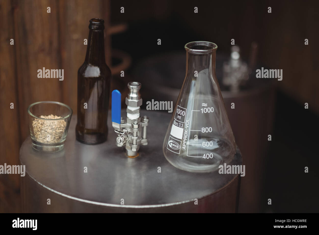 Glass of barley, flask and beer bottle on beer worts to make beer Stock Photo