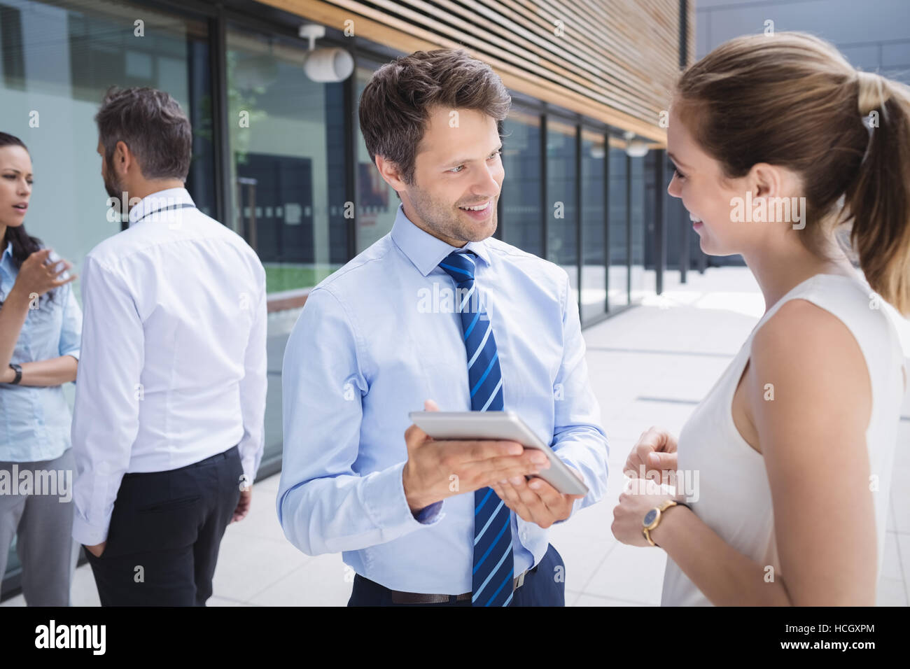 Businessman and colleague discussing over digital tablet Stock Photo