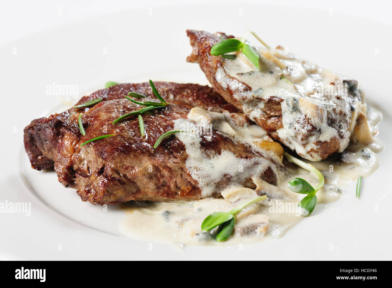 roasted beef steaks with rosemary under white sauce Stock Photo Alamy