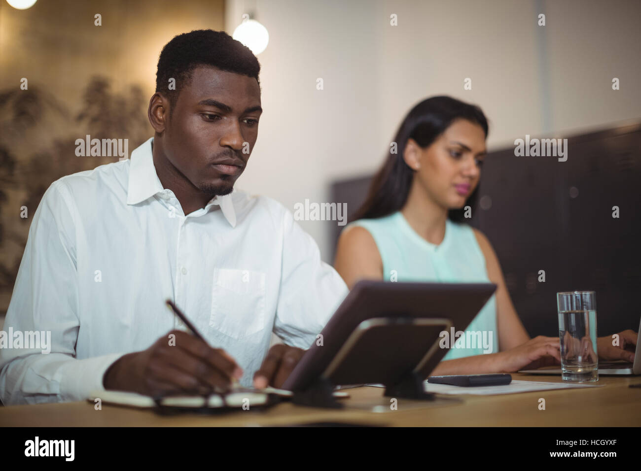 Businessman and a colleague working at their desk Stock Photo