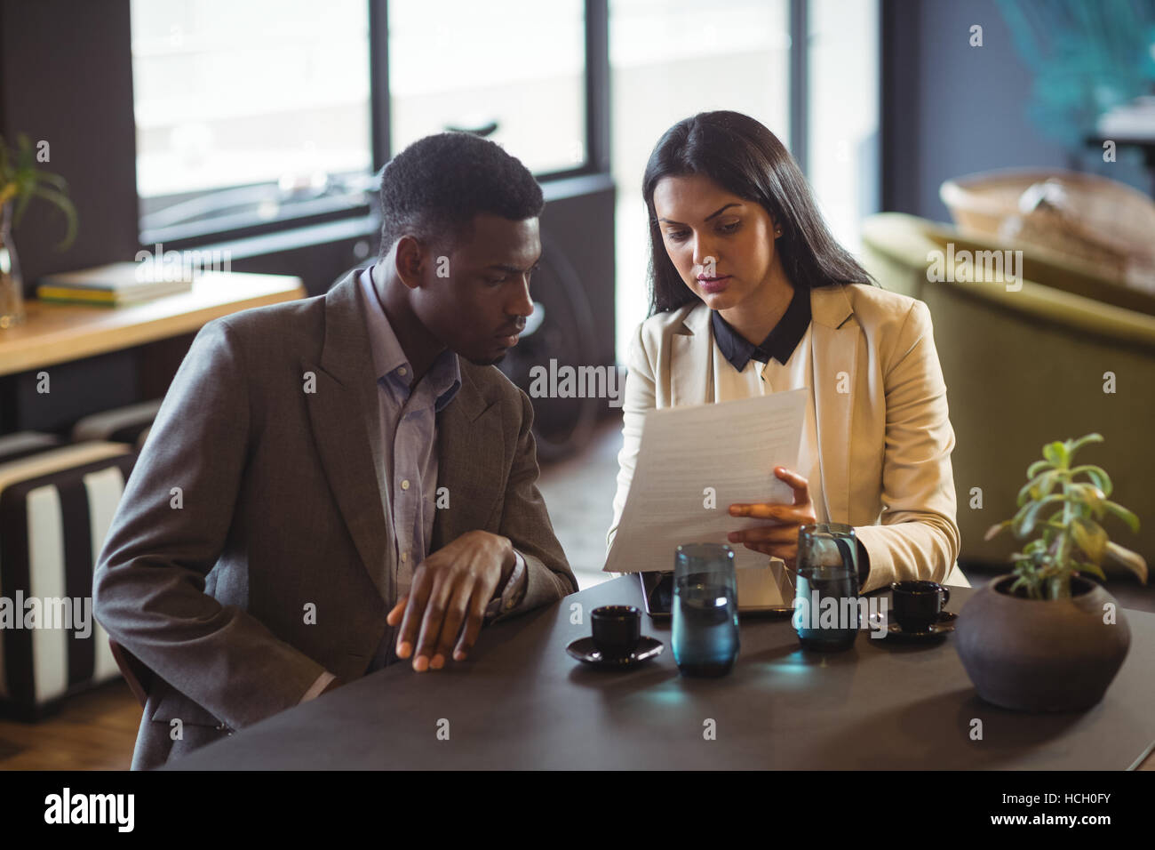 Businessman and a colleague discussing over document Stock Photo