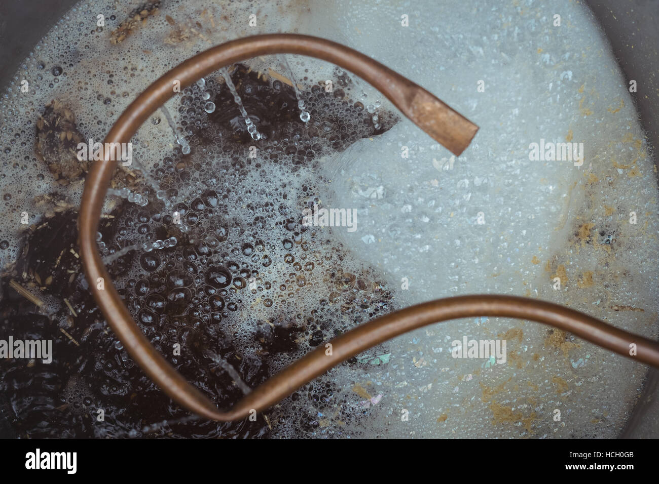 Copper pipe and boiling beer wort Stock Photo
