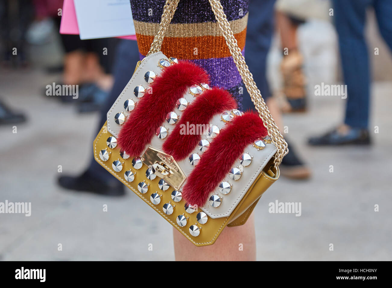 Woman with Hibourama bag with red fur and studs before Cristiano Burani fashion show, Milan Fashion Week street style, 2016 Stock Photo