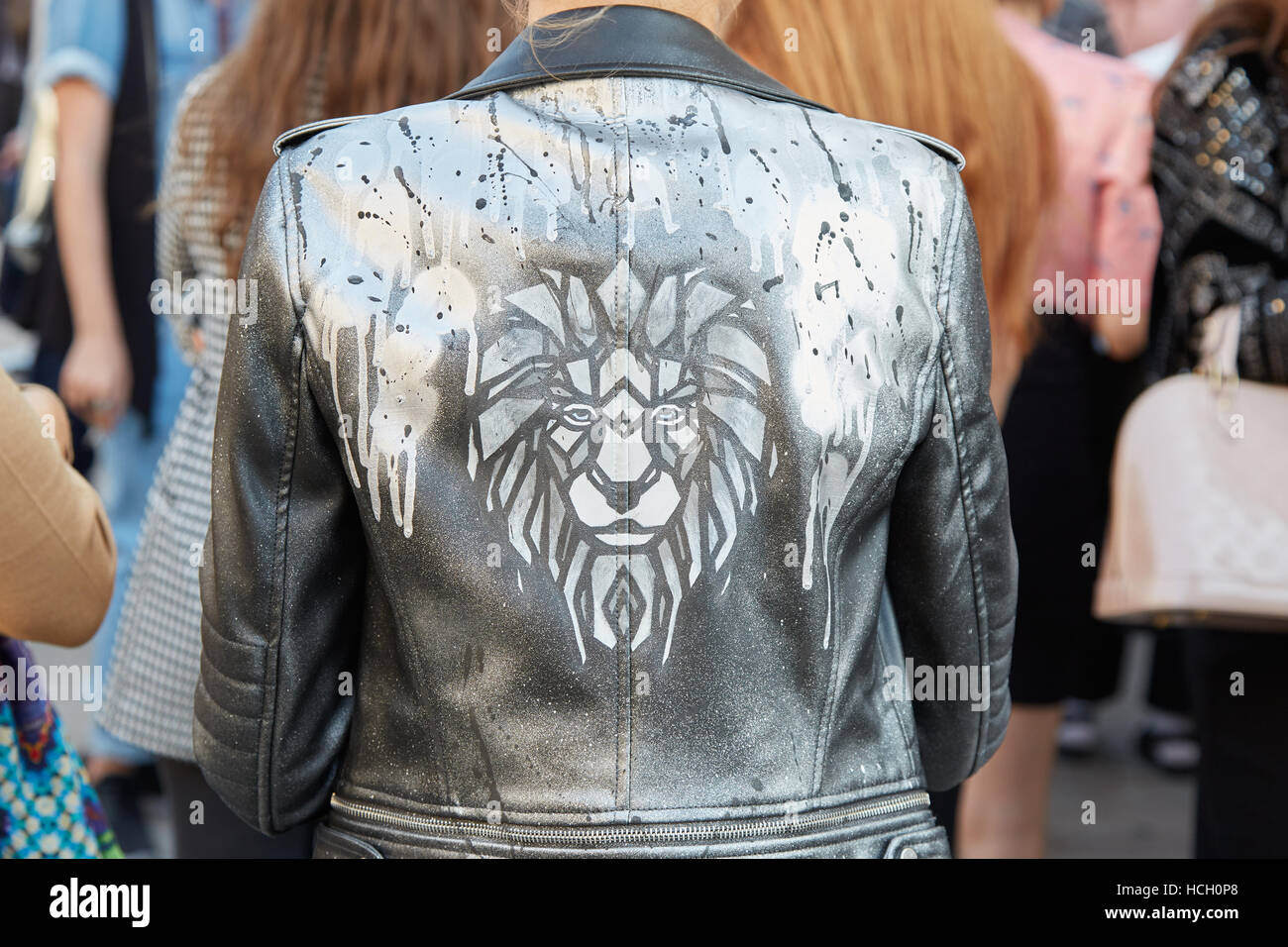 Woman with lion head print on black leather jacket before Cristiano Burani fashion show, Milan Fashion Week street style, 2016. Stock Photo