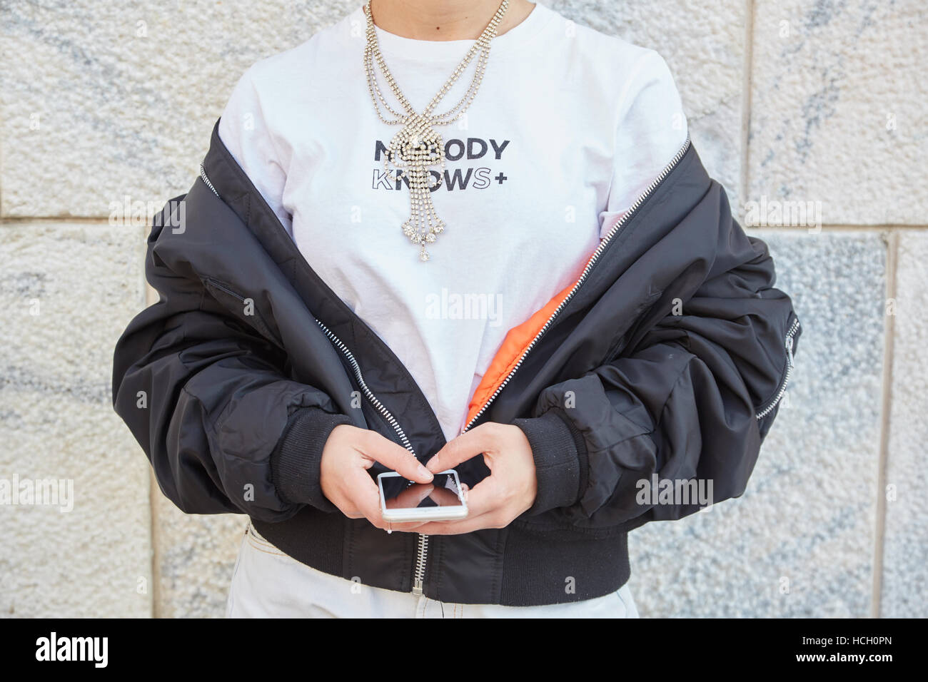 Woman with Nobody knows white t shirt before Cristiano Burani fashion show, Milan Fashion Week street style on September 22. Stock Photo
