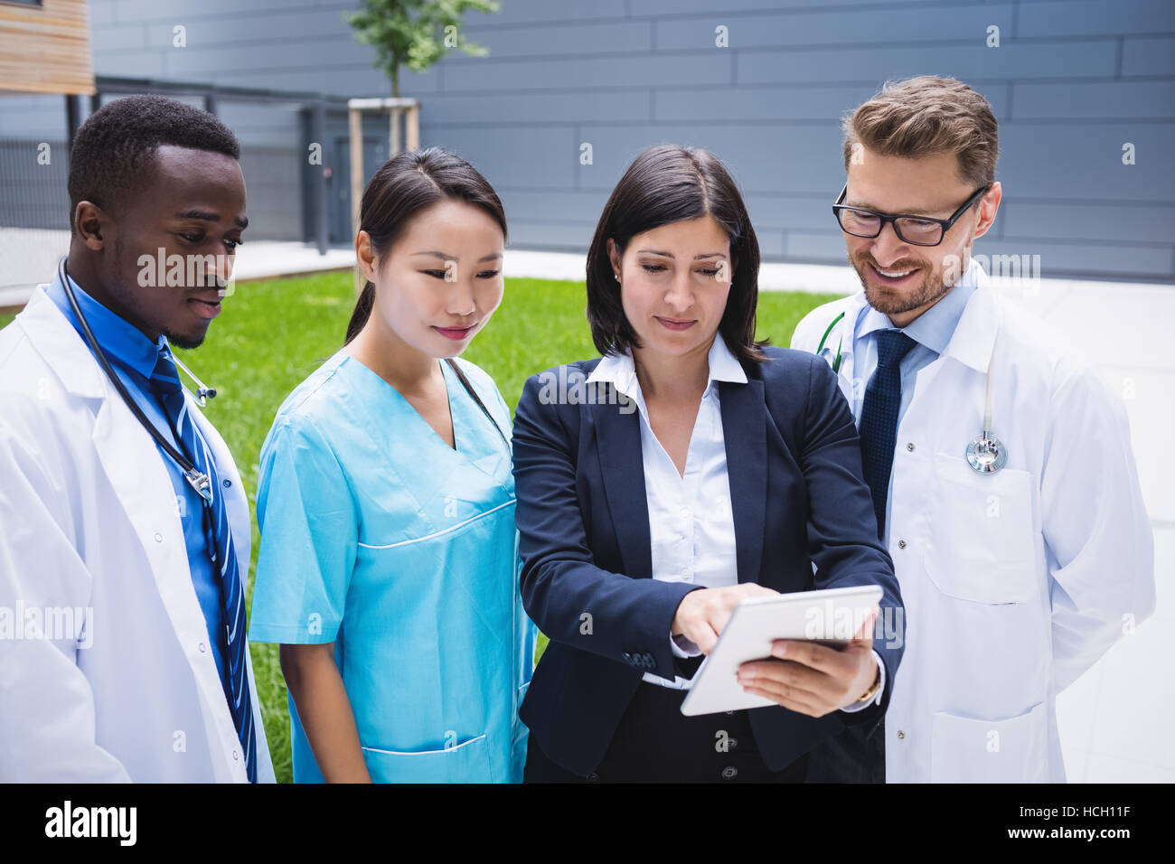 Team of doctors discussing over digital tablet Stock Photo