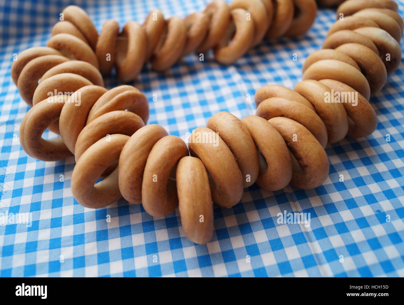 Macro view of delicious bagel doughnuts on the ribbon on the blue square paper towel Stock Photo