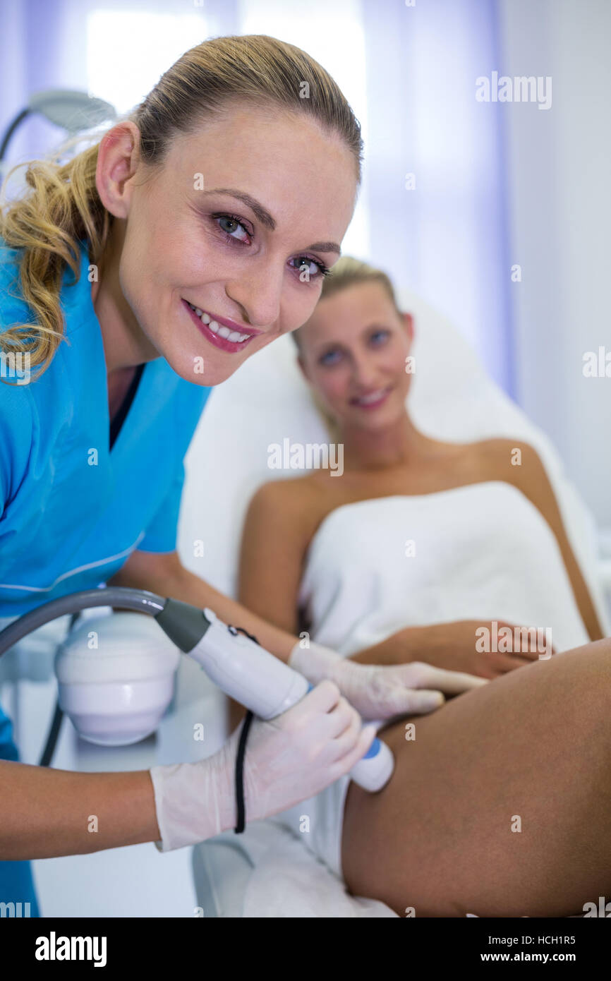 Woman receiving laser epilation treatment on her thigh Stock Photo