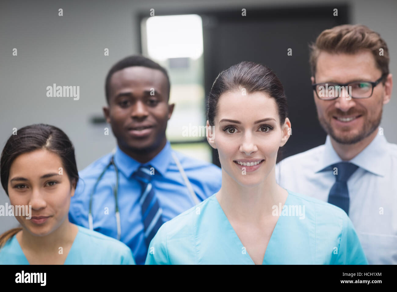 Smiling medical team standing together in hospital corridor Stock Photo