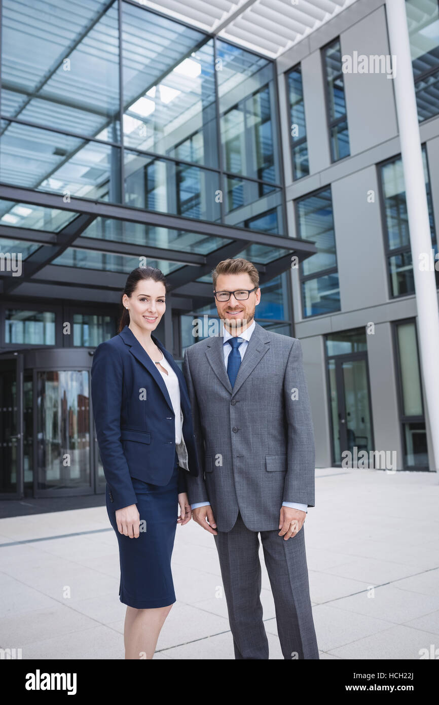 Confident businessman with colleague standing outside office building Stock Photo