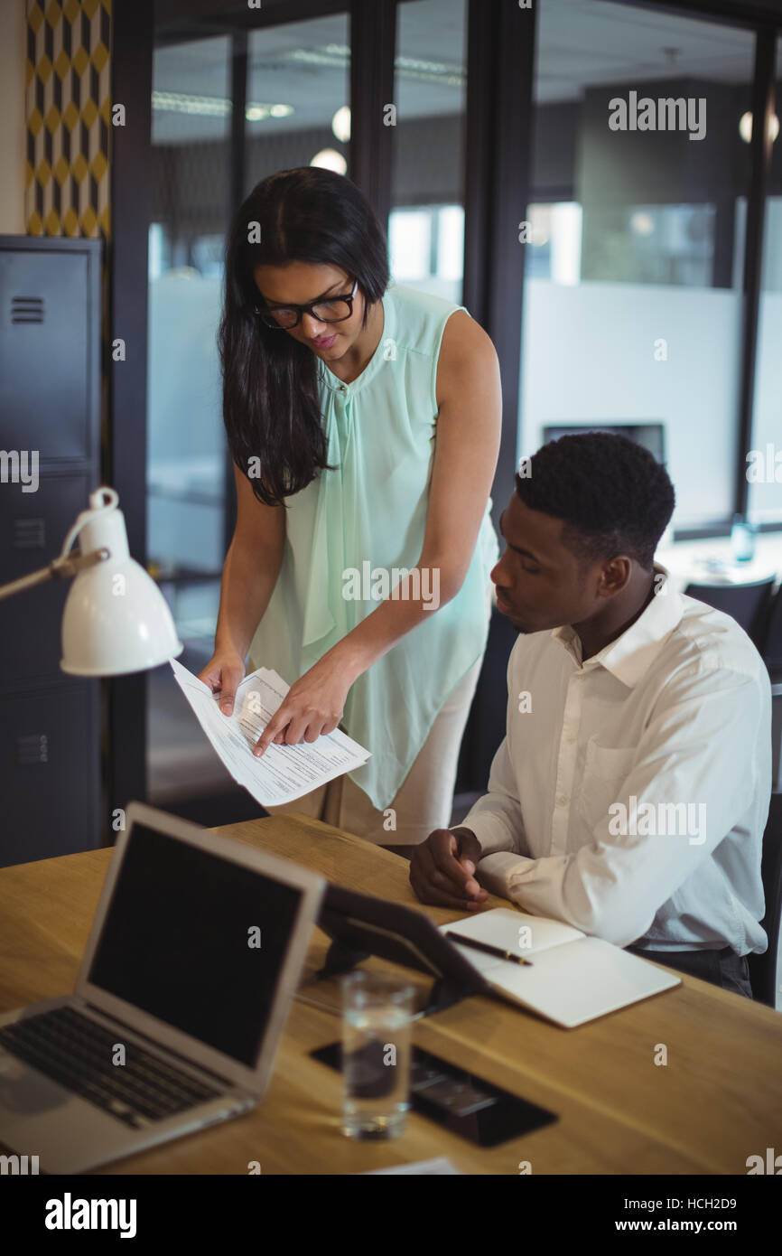 Businessman and a colleague discussing over document Stock Photo