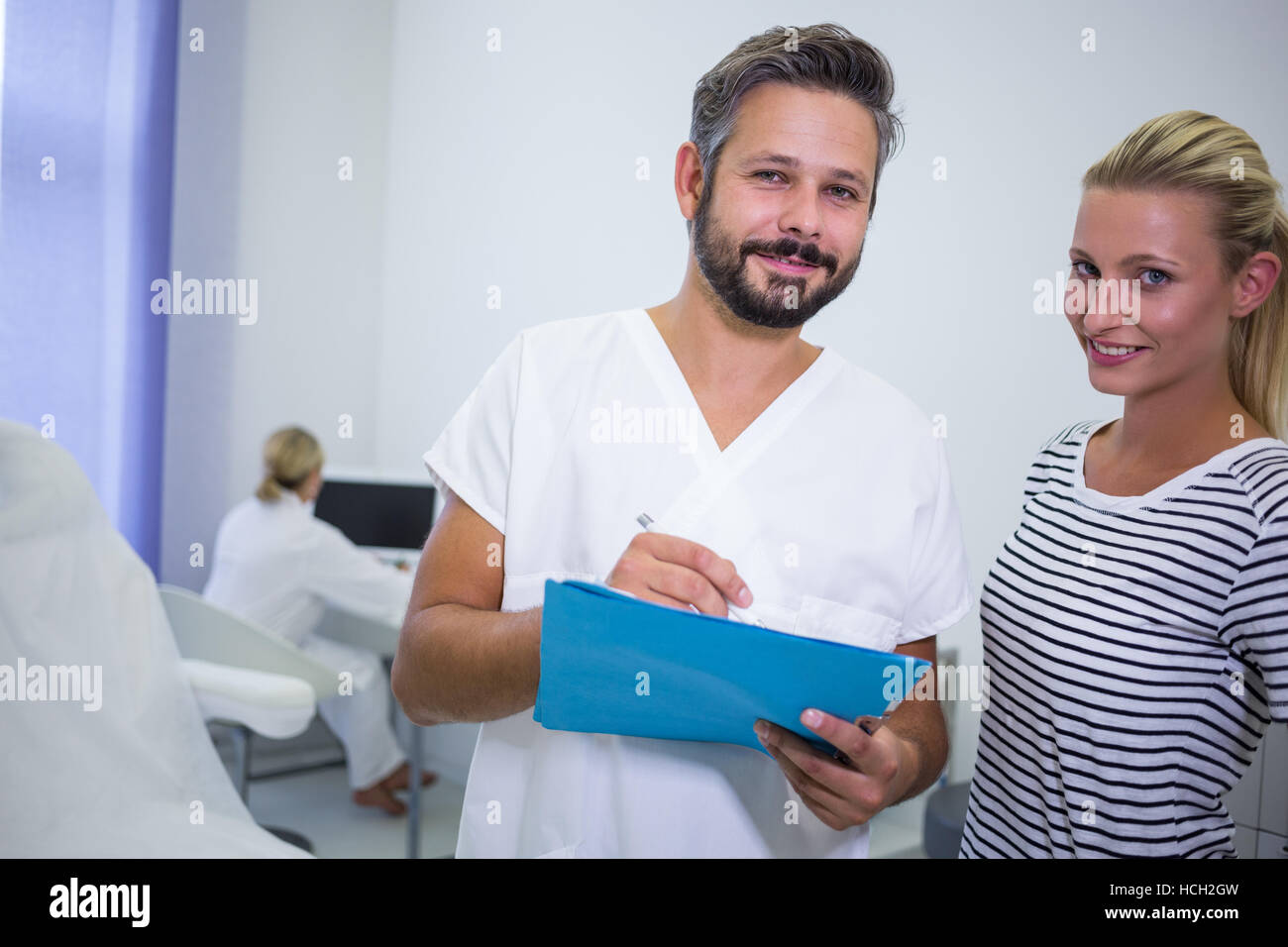 Doctor discussing reports with patient at clinic Stock Photo