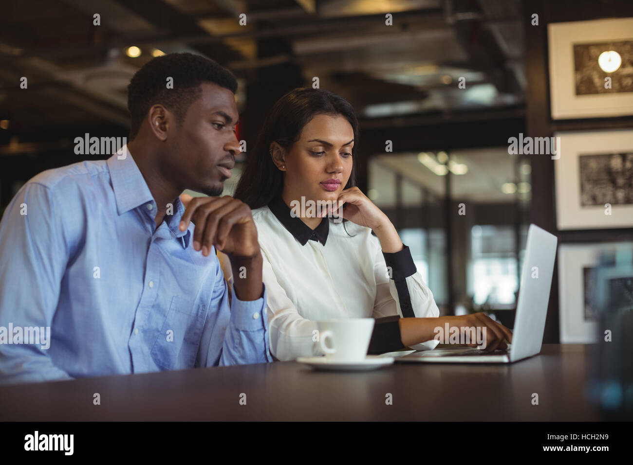 Businessman and a colleague discussing over laptop Stock Photo
