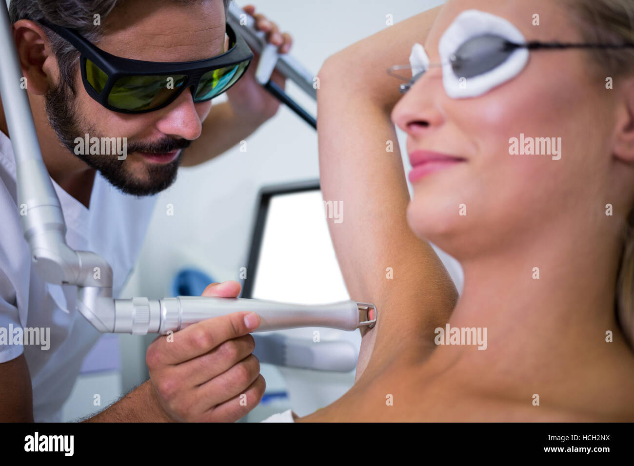 Dermatologist removing hair of patient armpit Stock Photo