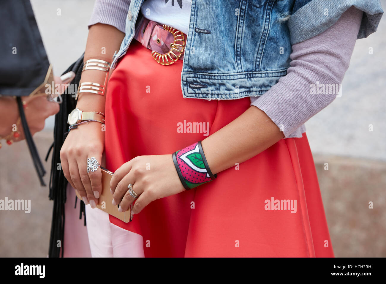 Woman with red skirt and colorful bracelet before Cristiano Burani fashion show, Milan Fashion Week street style on September 22 Stock Photo