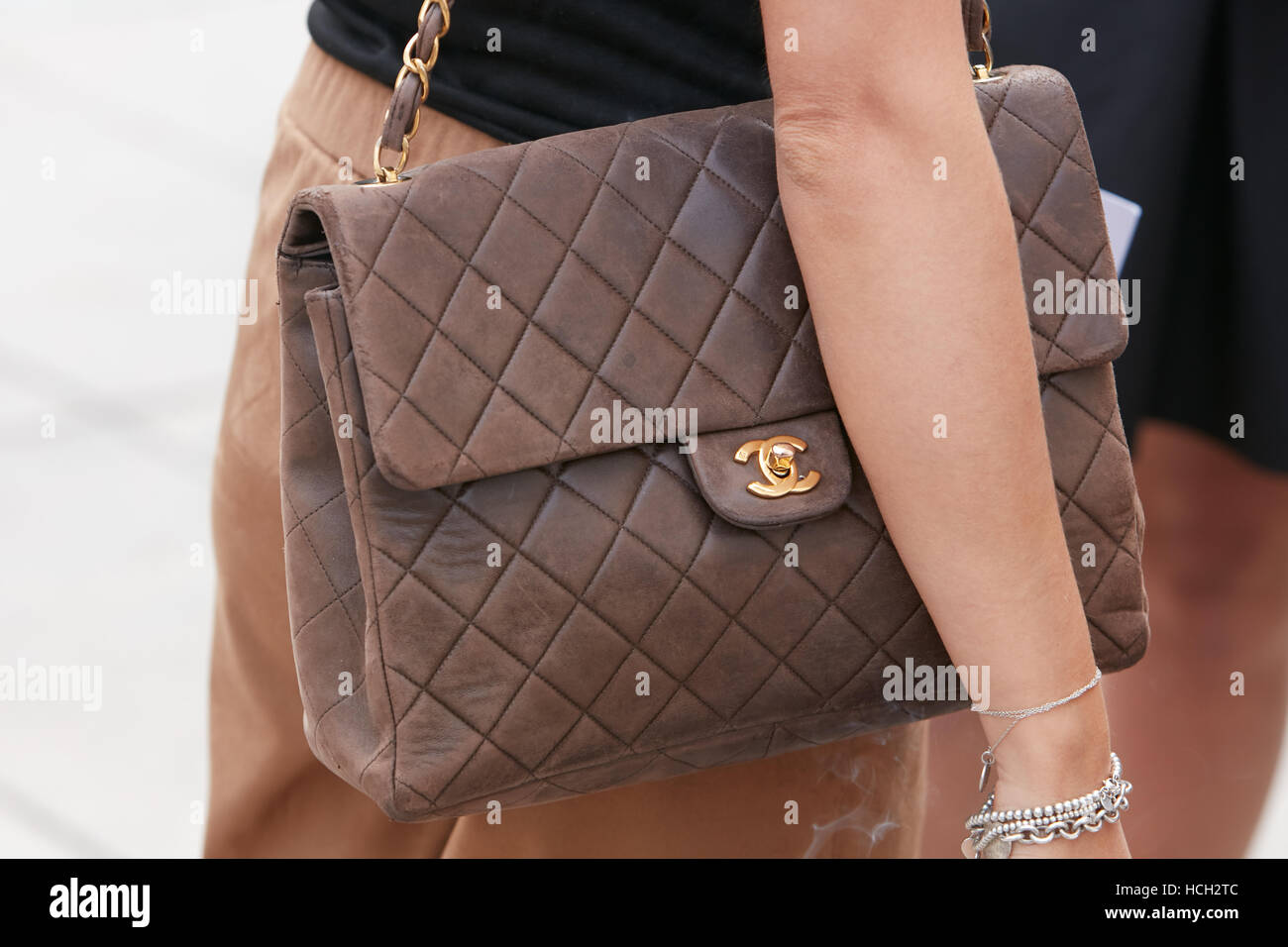 Woman with brown leather Chanel bag before Cristiano Burani