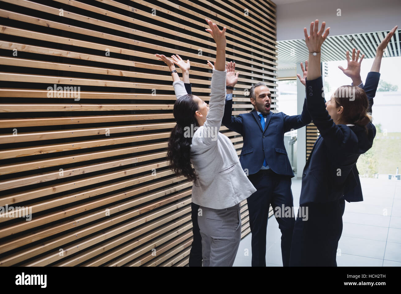 Businesspeople standing with hands raised Stock Photo