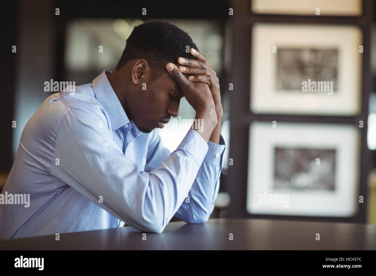 Stressed businessman sitting at his desk Stock Photo