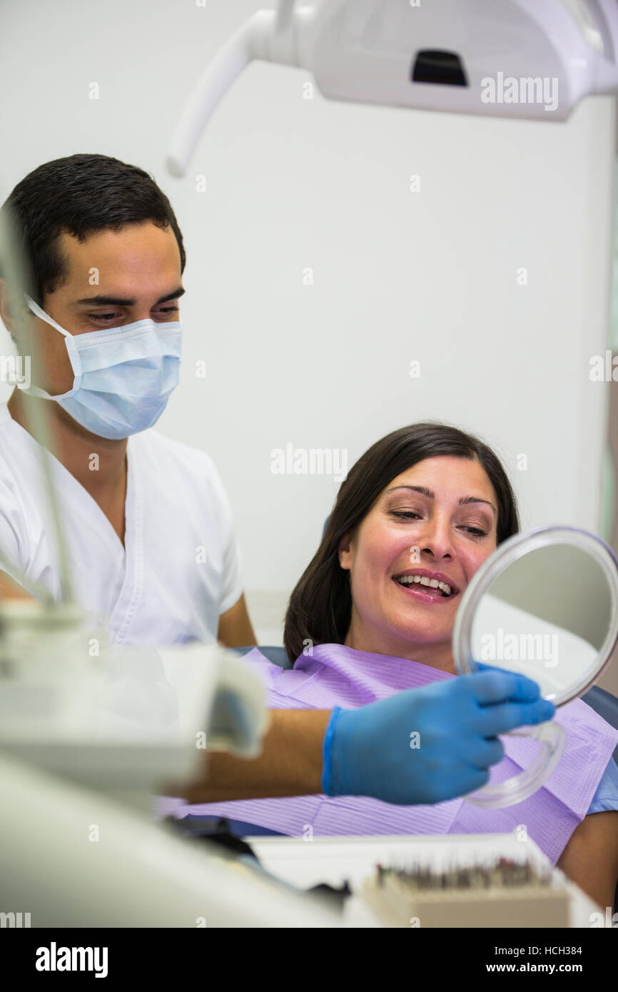 Dentist holding mirror in front of patient Stock Photo Alamy