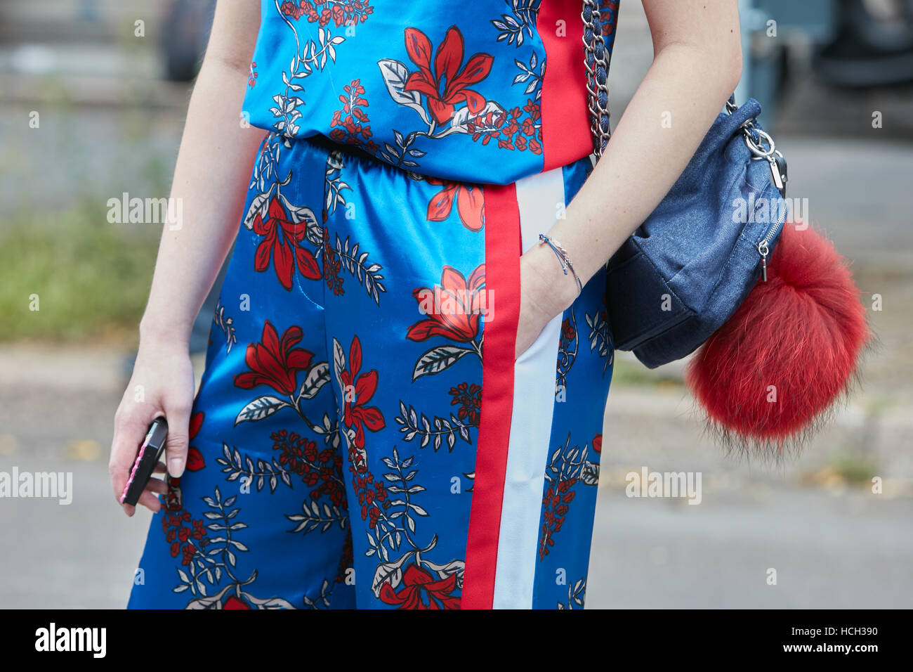 Woman blue, red, satin floral with before Fendi fashion show, Milan Fashion Week street style on September 22, 2016 in Milan. Stock Photo