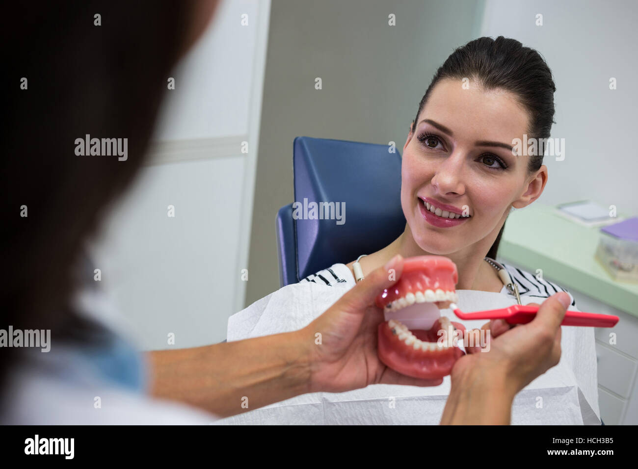 Dentist showing set of model teeth to the patient Stock Photo - Alamy