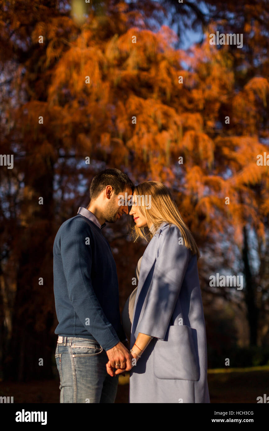 Pregnant woman and man posing at autumn park Stock Photo - Alamy