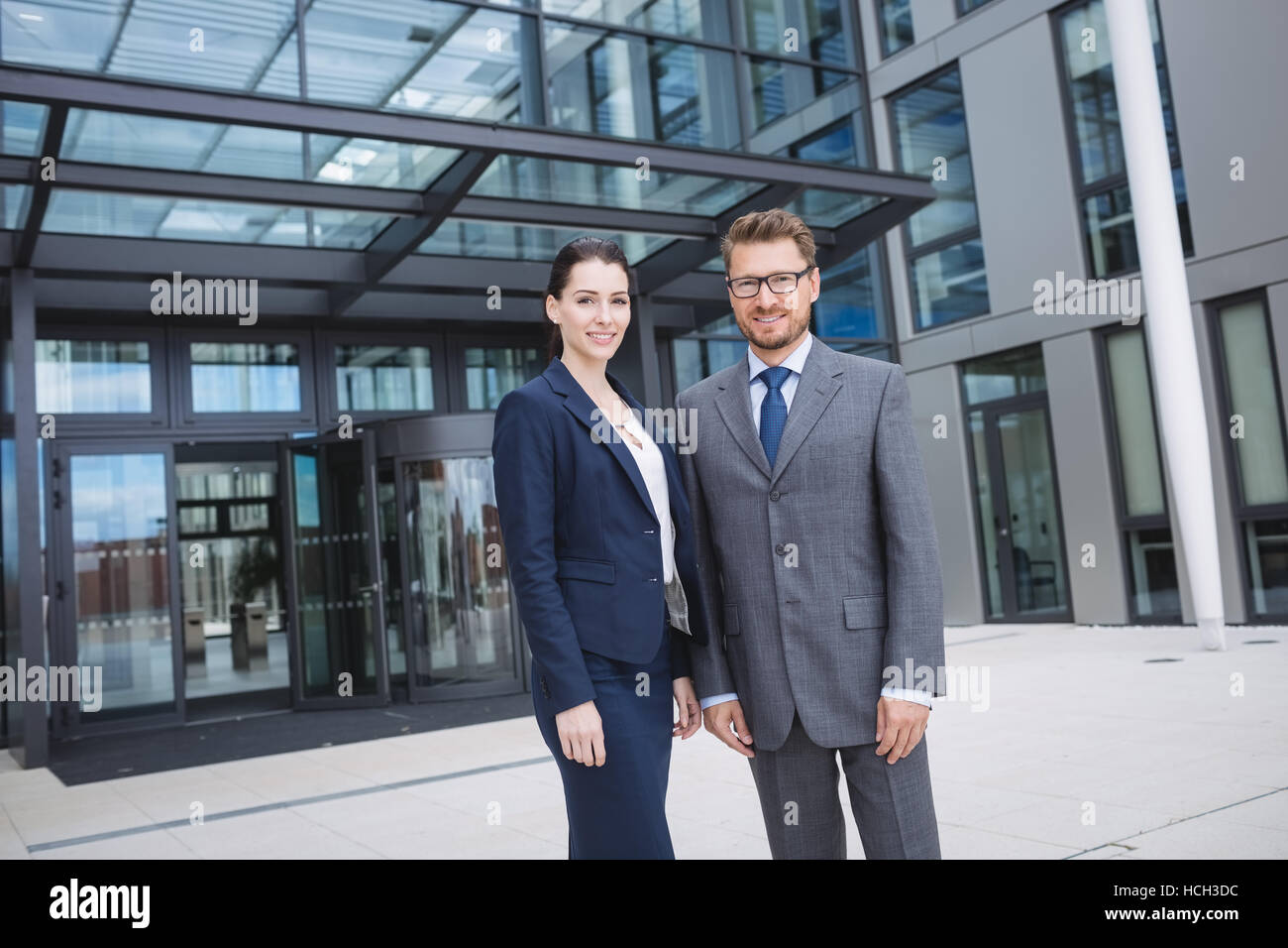 Confident businessman with colleague standing outside office building Stock Photo